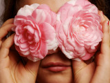 Young Girl Holding Camellia Flowers over Her Eyes Photographic Print by Oliver Strewe