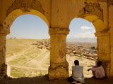 Locals Chat under Arches of Old Tomb with City in Background. Photographic Print by Stephane Victor