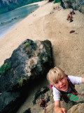 Young Boy Climbing Rocks Above Beach Photographic Print by Philip & Karen Smith