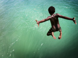 Torres Strait Islander Boy Leaping into the Sea, Seisia, Cape York Fotografie-Druck von Tim Barker