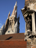Saint Statue Decorating Corner of House with Tower of Church of Our Lady in Background Fotografisk trykk av Bruce Bi