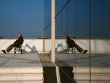 Man on Bench Reflected in Mirrored Window of Building Along Grado Promenade Near Town Centre Photographic Print by Ruth Eastham & Max Paoli