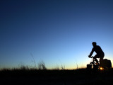Man Cycle Touring at Dawn Fotografisk trykk av Andrew Bain Man Cycle Touring at Dawn Fotografisk trykk av Andrew Bain
