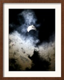 The Moon Partially Covers the Sun Behind the Clouds During a Partial Solar Eclipse Framed Photographic Print