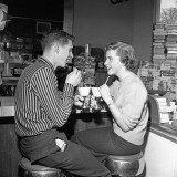Teen Couple on Stools at Soda Fountain Drinking Shakes and Smiling at Each Other Photographie par H. Armstrong Roberts