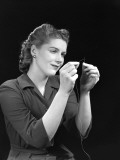 Woman in a Dark Dress Threading a Needle With Her Photographic Print by H. Armstrong Roberts