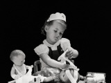 Girl Wearing Nurse's Cap, Putting Bandages on Doll's Head Photographic Print by H. Armstrong Roberts