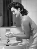 Woman Washing Hands at Bathroom Sink Photographic Print by George Marks