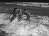 Two Young Man and Woman Playing in Wave Photographic Print by George Marks