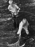 Two Boys Fishing; One Catching Fish in Net Photographie
