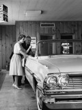 Couple Looking at Convertible in Showroom Photographie