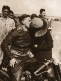 Woman Kissing Motorcycle Racer Photographic Print