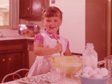 Girl Mixing Batter in a Bowl at Kitchen Table, Circa 1960's Photographic Print by L. Willinger