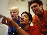 One Man and Two Women Looking at Computer Screen Photographic Print