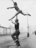 Male Acrobat on Unicycle Supporting Woman in Air Photographic Print