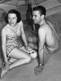 Young Couple Sitting Under Beach Umbrella Photographic Print