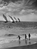 Three Boys Running Along Beach, Following Four Sailboats Out on Ocean Photographic Print