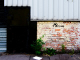 Side of Derelict Buidling with Metal Doorway and No Tipping Sign Photographic Print by Clive Nolan