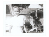 Family Snapshot of Boy in Front of House Posters