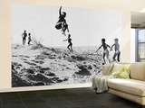 Bushman Children Playing Games on Sand Dunes Wall Mural – Large par Nat Farbman