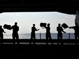 Sailors Pass Supplies to Each Other in the Hangar Bay of USS Ronald Reagan Photographic Print by  Stocktrek Images