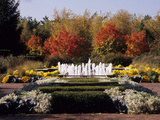 A Bubbling Fountain Surrounded by Plants and Colorful Trees Photographic Print by Paul Daimien