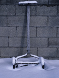 An Old Lawnmower Covered in Snow Against a Cinderblock Wall Photographic Print by Paul Daimien