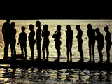 A Backlit View of Swimmers on a Dock on Lake Banyoles Photographie par Tino Soriano