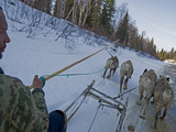 Komi Reindeer Herder Drives His Team Along a Dangerous Melting Stream Photographie par Gordon Wiltsie