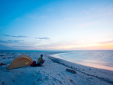 A Solo Camper Watches the Sunset from a Tiny Island Far Out to Sea Photographic Print by Ben Horton