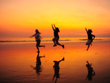 Silhouetted Children Playing on the Beach at Sunset Photographie par Jorge Fajl