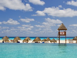 The Caribbean Sea, Tiki Huts and a Lifeguard Stand from a Resort Pool Photographic Print by Mike Theiss