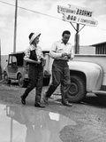 A Man and Woman Dodge a Puddle in the Street Photographie par Thomas J. Abercrombie