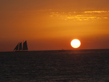 A Boat Sails across the Horizon at Sunset Photographie par Karen Kasmauski