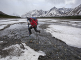 A Hiker Attempts to Keep His Feet Dry While Crossing a River Photographic Print by Michael Christopher Brown