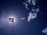 An American Flag Against a Glowing Sun Photographic Print by Aaron Huey