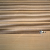 Aerial Shot of a Tractor Cultivating Photographic Print by Klaus Leidorf