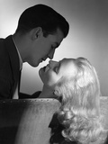 1940s 1950s Movie Star Studio Style Romantic Couple Embracing On Sofa Photographic Print by DeBrocke