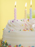 Lit candles on a cake Photographic Print