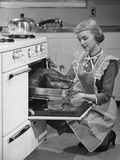 Young woman putting turkey into oven - Fotografik Baskı