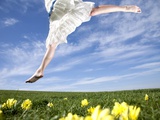 Young woman in park jumping on lawn Photographic Print