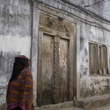 Zanzibar, Tanzania. a Zanzibari Women in Traditional Khanga Robes, Passing an Old Wooden Door in St Photographic Print by Steve Outram