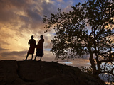 Two Maasai Men Silhouetted on a Hill at Sunset Photographie par Nigel Pavitt