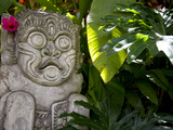 Bali, Ubud, a Stone Carving, Adorned with a Hibiscus Flower, Sits in Tropical Gardens Photographic Print by Niels Van Gijn