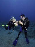 Divers on a Reef Reading a Fish Identification Book Underwater, Palau, Micronesia Photographic Print by David Fleetham
