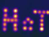 Thermogram - Warmed Stones Arranged to Spell the Word Hot Photographic Print by Chuck Swartzell