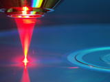 Red Laser Reading or Writing a Dvd Disc Photographic Print by  GIPhotoStock