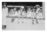 Children Sit on Wall in Front of Stands at the Ballpark and Eat Ice Cream Cones. Posters