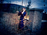 A Young Woman with Red Hair Wearing a Long Blue Gown, Standing Outside Pointing to a Garden Photographic Print by Elizabeth May