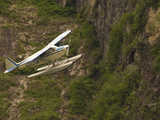 A Bush Pilot Flies His Float Plane Close to Mountain in Alaskan Canyon, USA Photographic Print by John Alves